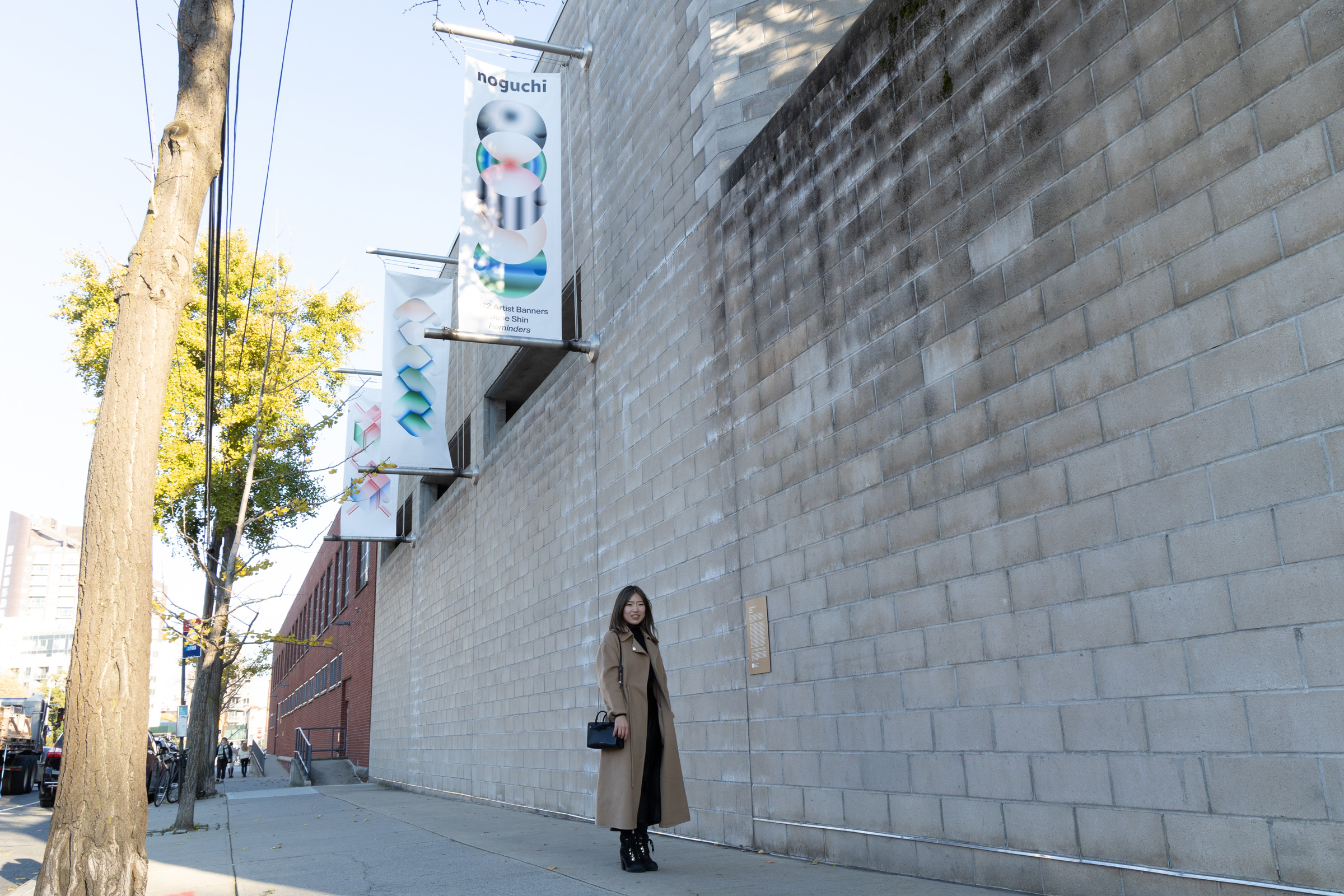 Artist June Shin in front of her artist banners ‘Reminders’ installed on the exterior of the Noguchi...